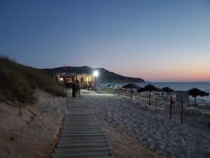 Una pareja caminando por la playa por la noche en Casa Pinella en Villamassargia