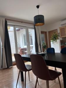 una sala da pranzo con tavolo e sedie neri di HB Downtown Sunny Apartman a Budapest
