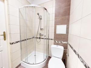 uma casa de banho com um chuveiro e um WC. em roomspoznan pl - Pokoje Królowej Jadwigi 44 - 24h self check-in em Poznań