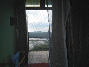 a window in a room with a view of the water at ARROW Haputale village inn in Haputale