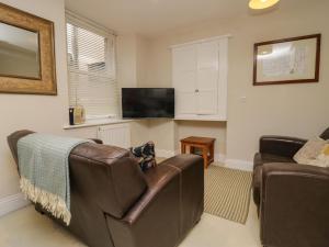 a living room with a couch and a television at Printers Cottage in Cockermouth