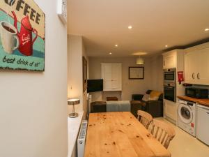 a kitchen and living room with a wooden table in a room at Printers Cottage in Cockermouth