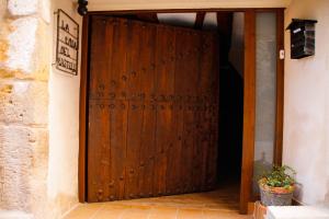 a wooden door in a room with a plant at La Casa del Castell - Encanto rural junto al Parque Natural de els Ports in Horta de San Joan