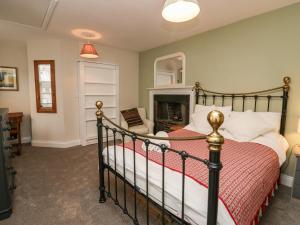 a bedroom with a bed and a fireplace at Printers Cottage in Cockermouth