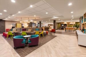 un vestíbulo de un hospital con mesas y sillas coloridas en Hawthorn Extended Stay by Wyndham Kingwood Houston en Kingwood
