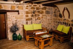 a room with a stone wall with a couch and a table at La Casa del Castell in Horta de San Joan