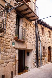 a stone building with a door and a balcony at La Casa del Castell in Horta de San Joan