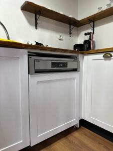 uma cozinha com armários brancos e uma máquina de lavar louça em Haremi Garden Suit Bungalows em Tokat