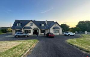 a large house with cars parked in a parking lot at Spacious House in beautiful Malin Head in Keenagh