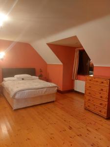 a bedroom with a bed and a dresser in a room at Spacious House in beautiful Malin Head in Keenagh