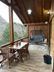 a screened in porch with a table and a chair at Haremi Garden Suit Bungalows in Tokat