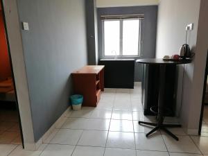 a small room with a table and a window at Globallon Services Apartment, Melaka Town Hotel in Malacca