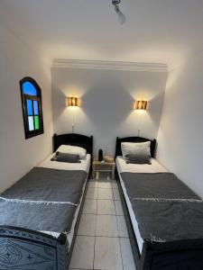 een slaapkamer met 2 bedden en een raam bij Riad Sana in Marrakesh
