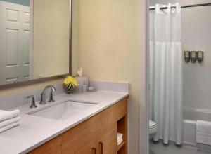 y baño con lavabo y ducha. en Parsippany Suites Hotel, en Parsippany