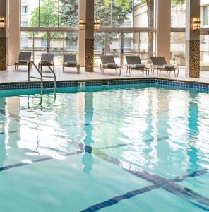 a swimming pool in a hotel with chairs and windows at DoubleTree by Hilton Minneapolis Airport, MN in Bloomington
