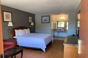 a bedroom with a white bed and a red couch at Howard Johnson by Wyndham Azusa in Azusa