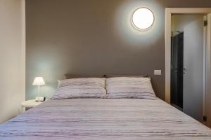 a bedroom with a large bed with a light on the wall at Bergamo bnb in Villa di Serio