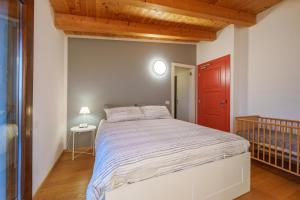 a bedroom with a large bed with a red door at Bergamo bnb in Villa di Serio