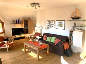 a living room with a couch and a table at Oewern Diek App 05 in Wustrow