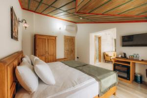 a bedroom with a large bed and a television at Cappadocia Villa Comfort in Nevsehir