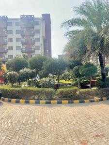 ブリンダーバンにあるZenRoofs - Brij Bhumi Haven 2の建物のある都市のヤシの木がある公園 +9枚の写真
