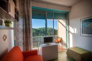 a living room with a television and a balcony at Monolocale CM in Follonica