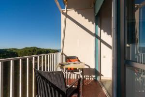 a balcony with two chairs and a table with books at Monolocale CM in Follonica +6 photos