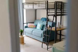 sala de estar con sofá azul y litera en BRONZET - T1 à 14 min à pied de la Plage de la Verrerie en Marsella