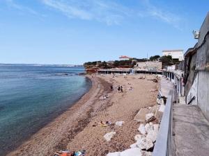una playa con gente tirada en la arena y el agua en BRONZET - T1 à 14 min à pied de la Plage de la Verrerie en Marsella