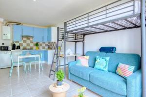 sala de estar con sofá azul y cama elevada en BRONZET - T1 à 14 min à pied de la Plage de la Verrerie en Marsella