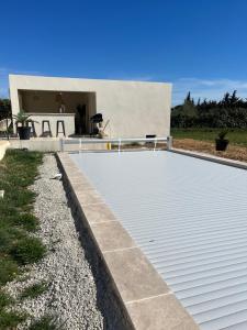 una imagen de una piscina vacía frente a una casa en En apparté en Arlés