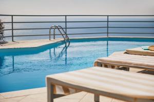 a swimming pool with two chaise lounges next to at Athens Riviera Villa in Anavyssos