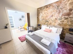 una camera con un grande letto e un muro di pietra di Cozy Home with Yard & Cottage Charm in Athens ad Atene