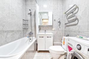 a bathroom with a toilet and a tub and a sink at Апартаменты возле ЭКСПО in Astana