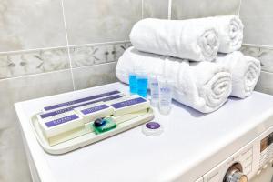 a bathroom with towels and a pile of towels at Апартаменты возле ЭКСПО in Astana