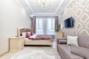 a bedroom with a bed and a couch at Апартаменты возле ЭКСПО in Astana