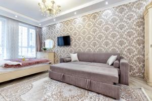 a bedroom with a bed and a couch at Апартаменты возле ЭКСПО in Astana