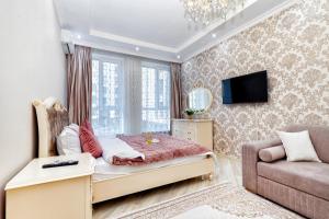 a bedroom with a bed and a couch at Апартаменты возле ЭКСПО in Astana