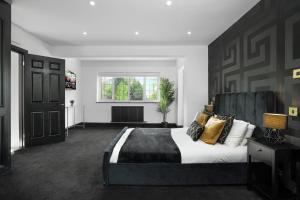 - une chambre avec un grand lit et une tête de lit noire dans l'établissement Gorgeous 6 Bed House - Hot Tub - Wifi & Large Garden - Lichfield 40ST, à Shenstone