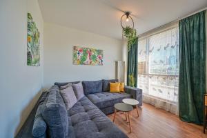 un soggiorno con divano blu e finestra di Tropicana Penthouse – 1 Bedroom a Sofia