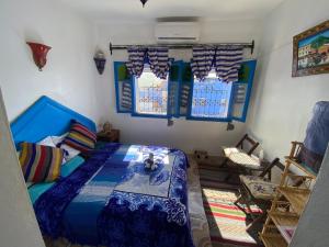 a bedroom with a bed in a room with windows at Riad sakura in Chefchaouen