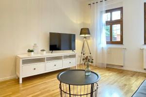 a living room with a tv and a table at Ferienwohnung Altstadtidyll in Lübbenau