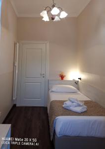 una camera bianca con due letti e una porta di Guest house Central Station a Milano