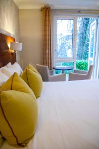 a bedroom with a large bed with yellow pillows at The Belsfield Hotel in Bowness-on-Windermere