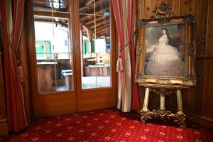 een schilderij van een vrouw in een jurk in een kamer bij Mercure Sighisoara Binderbubi Hotel & Spa in Sighişoara