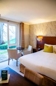 ボウネス・オン・ウィンダミアにあるThe Belsfield Hotelの大きなベッドと窓が備わるホテルルームです。