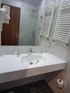 a bathroom with a white sink and a mirror at Hotel Comandor in Mamaia