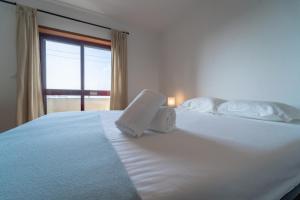 1 dormitorio con 1 cama blanca grande y ventana en Feliciano Ramos 1 - T4 familiar perto do centro da cidade - Braga, en Braga