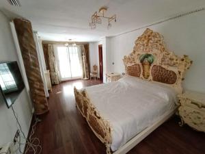 a bedroom with a large bed with a large headboard at Villa Esperanza in La Eliana
