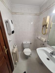 a bathroom with a toilet and a sink at Hotel Rooms Ducay in Olite